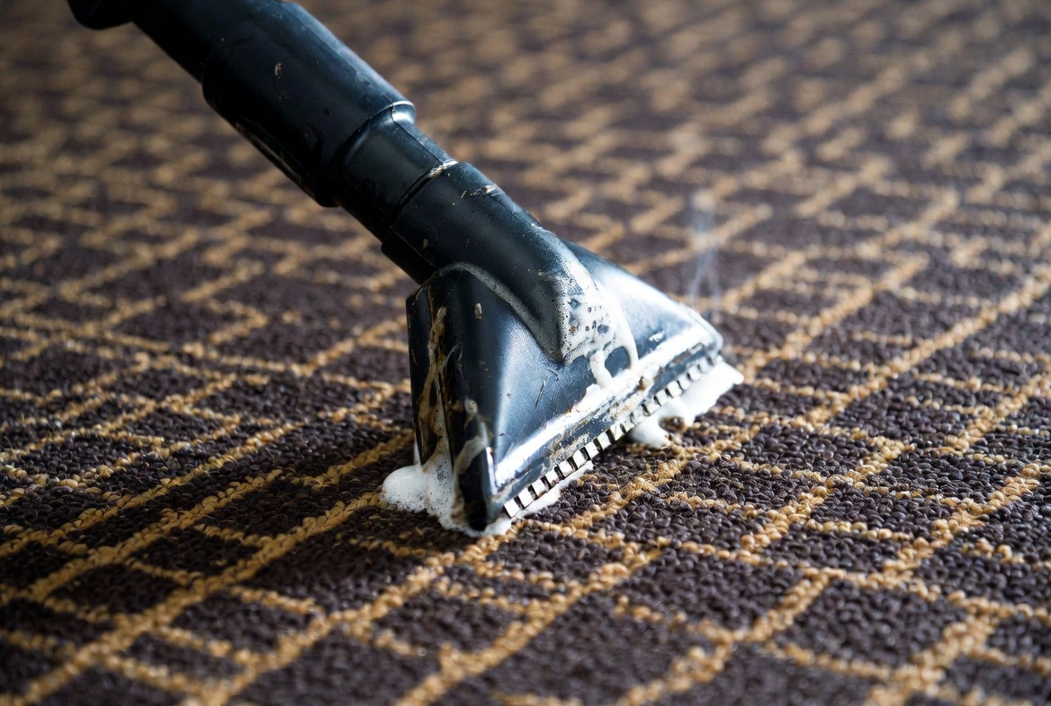 Close-up of commercial carpet extractor wand cleaning office carpet